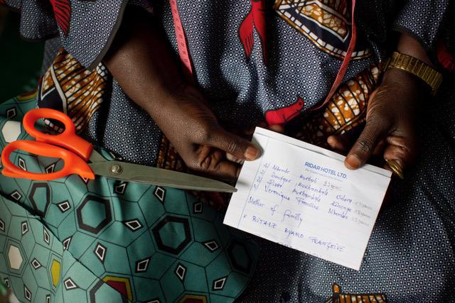 Bitale, a refugee in Nakivale, holds a piece of paper with the names of her children who she are still missing. 